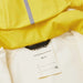Reima Kid's Lampi Rubber Rain Jacket in yellow, tag detail view
