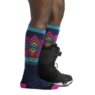 Darn Tough Women's Echo Over-the-Calf Midweight Ski & Snowboard Sock shown in the Eclipse color option on model.