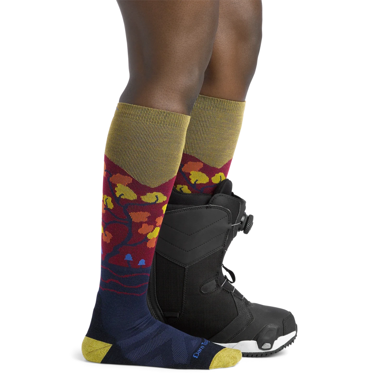 Darn Tough Womens's Enchanted Over-the-Calf Midweight Ski & Snowboard Sock shown in the Autumn design. Shown on model.