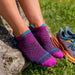 Darn Tough Women's Run No Show Tab Cushioned Ultra-Lightweight Running Socks in Blackberry, top view on model 