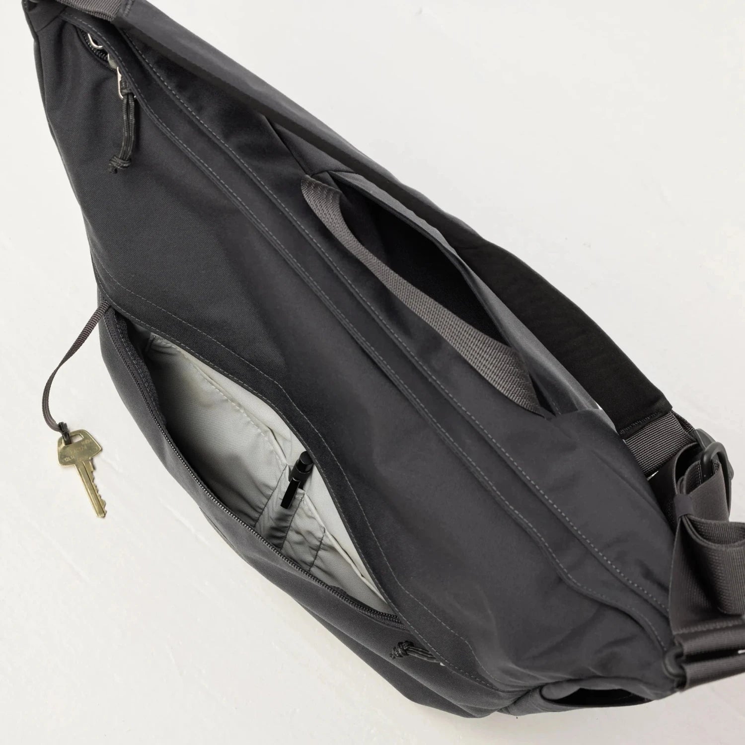 Fjall Raven Färden Crossbody in black, top view front pocket unzipped