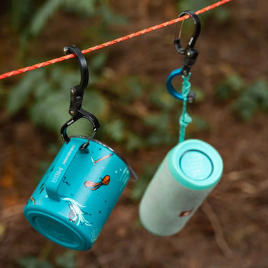 small gear clip attached to mug and next to small gear clip attached to speaker both hanging from a rope