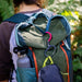 gear aid heroclip small carabiner is being used to hang a smaller bag on a backpack worn by a woman in a purple shirt