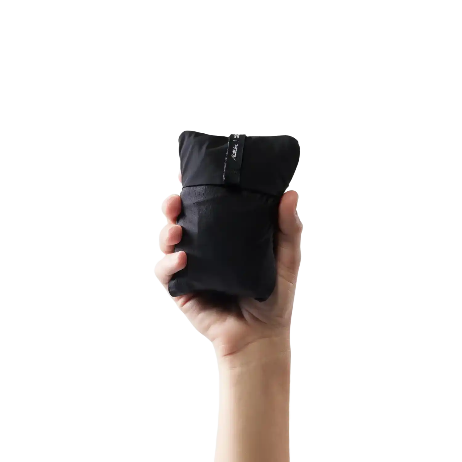 Matador Blackout Travel Pillow in Black, view of packed up pillow being held