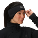 Person wearing a black headband with a brand logo on a plain background