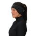 Woman wearing a black headband with a logo on a light gray background