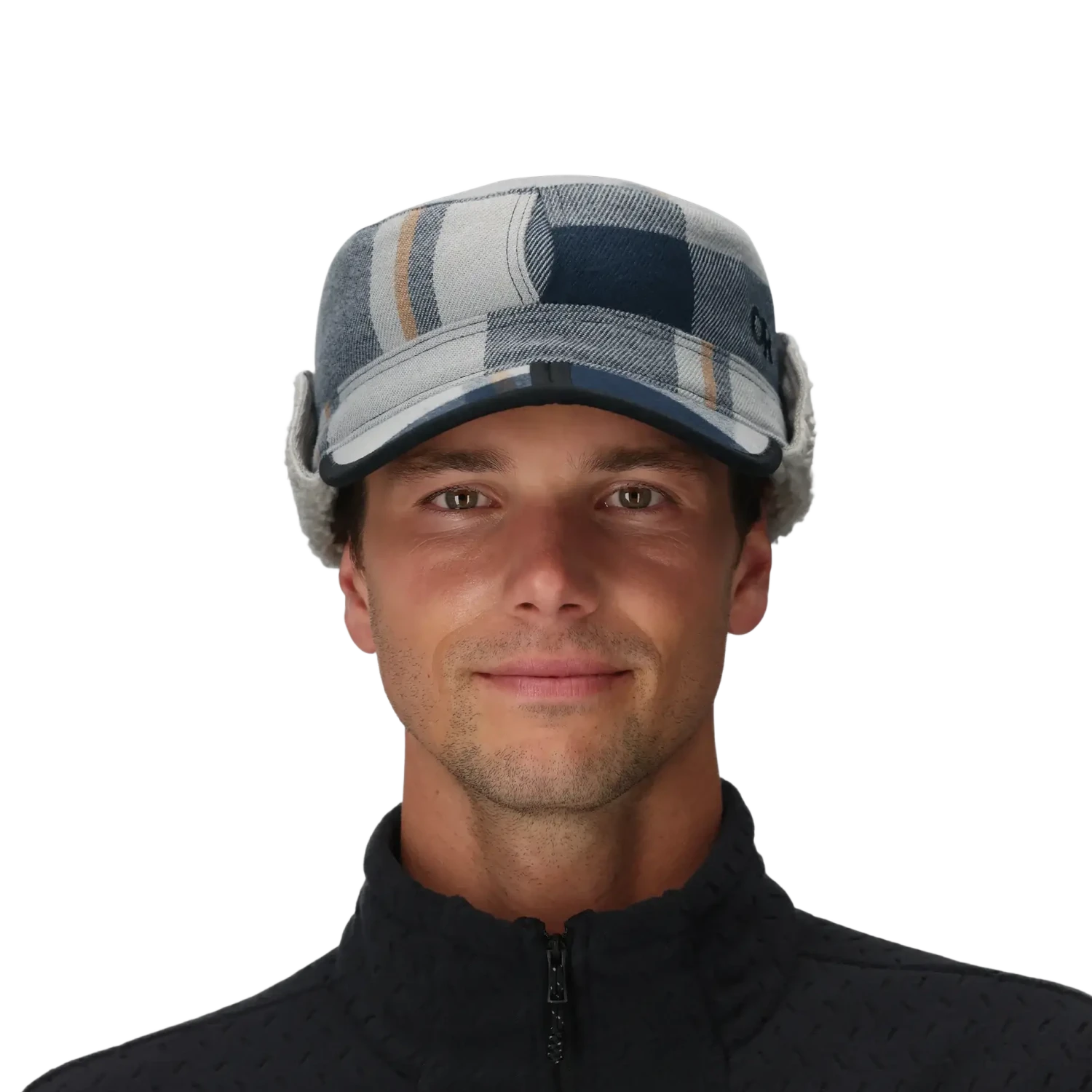 Man wearing a plaid cap with ear flaps on a gray background