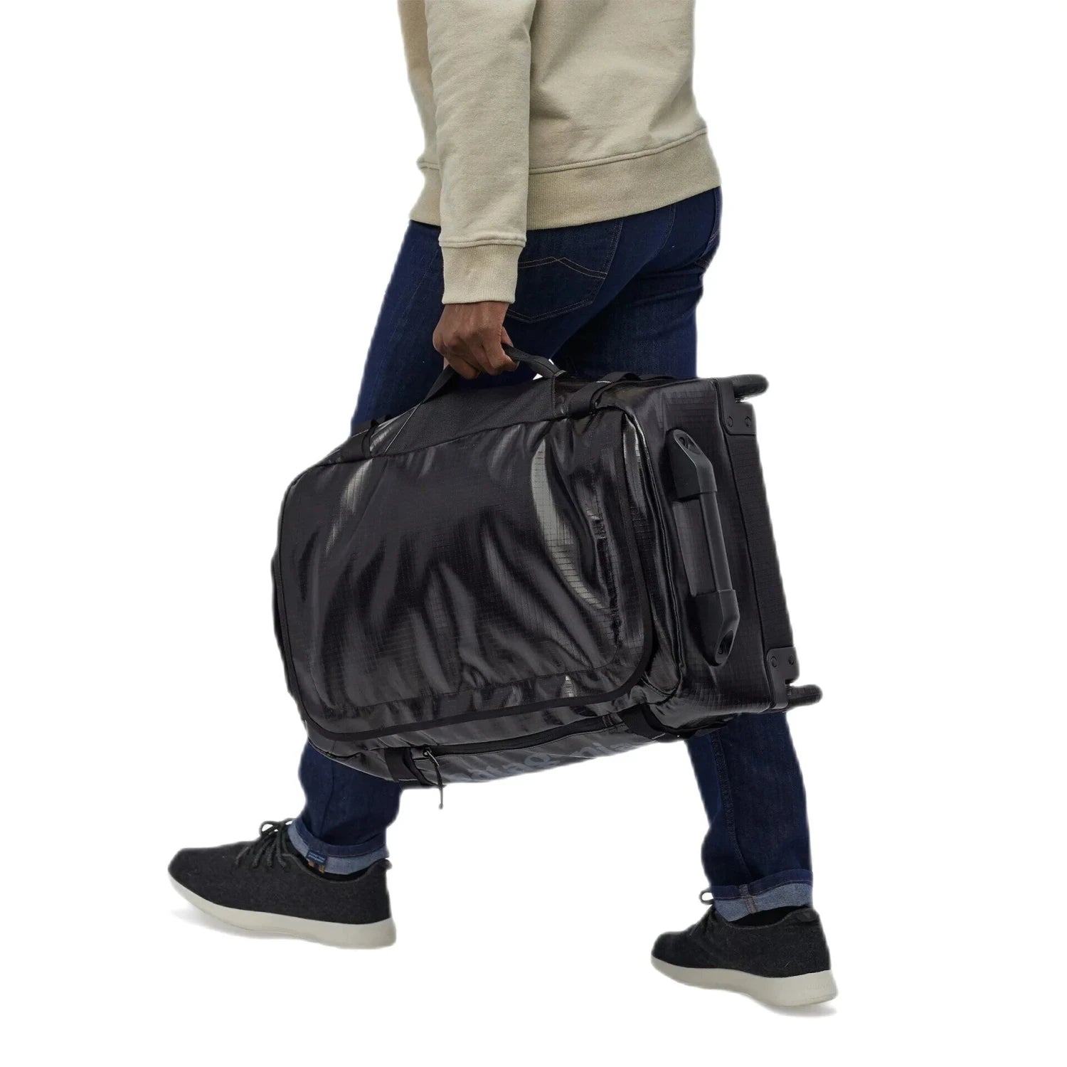 Patagonia Black Hole® Wheeled Duffel Bag 40L, Black, side view of model holding bag