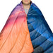 Rumpl Original Puffy Blanket in alpenglow, on model with cape clip