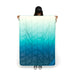 Rumpl Travel Puffy Blanket in deepfoam fade, held up in front of model