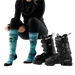 Person wearing black ski boots with blue patterned socks, standing next to two pairs of black ski boots on a white background.