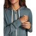 Vuori Women's Halo Performance Hoodie 2.0 shown in Lake Heather on model. Details view. Blue colored hoodie with white tie strings.