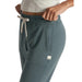 Vuori Women's Performance Jogger shown on model in Lake Heather, a blue-green color with white Tie Strings. Detail View.
